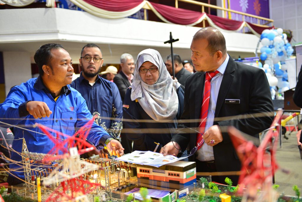 a group of people looking at a model of a building